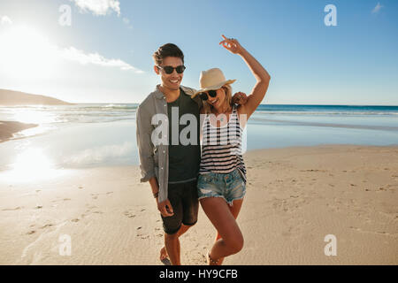 Portrait of happy young couple en train de marcher sur le bord de la mer. L'homme et la femme à profiter de l'amour à la plage. Banque D'Images