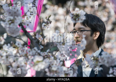 Tokyo, Japon. 3ème apr 2017. Un des hommes de prendre des photos sous les cerisiers en fleurs le Meguro River d'un pont dans la région de Tokyo. Affichage des cerisiers en fleurs est un passe-temps national et culturel au Japon, où des millions de personnes de les admirer chaque année. Credit : Alessandro Di Ciommo/ZUMA/Alamy Fil Live News Banque D'Images