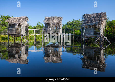 Trois maisons sur pilotis dans les eaux tranquilles de la tovara, San Blas, au Mexique. Banque D'Images