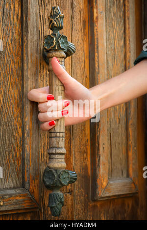 Belles femmes main sur vintage bouton de porte. Banque D'Images