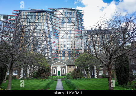 Hopton hospices du contraste avec le bureau moderne qui se profile l'évolution derrière eux. Construit en 1752, ils sont encore en usage aujourd'hui à la maison de personnes âgées Banque D'Images