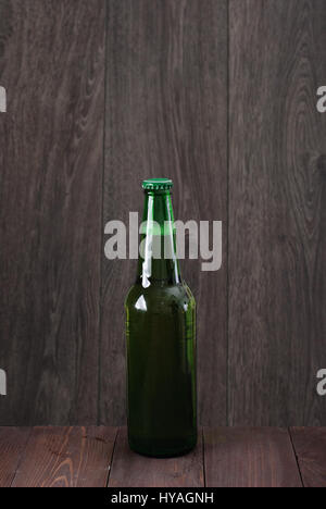 Bouteille de bière sur un fond de bois Banque D'Images