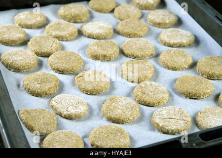 La préparation des témoins de quinoa, recette biscuits vegan - matières, non cuits) cookies disposés sur du papier sulfurisé dans une plaque à pâtisserie Banque D'Images
