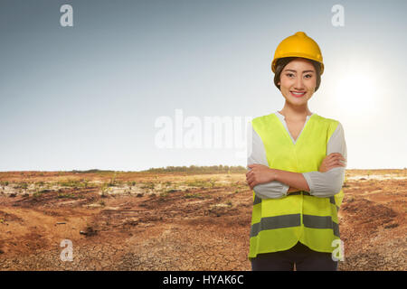 Jeune femme ingénieur asiatique avec gilet réfléchissant sur fond de terrain de construction Banque D'Images