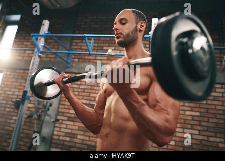 L'homme musclé barbell levage in gymnasium Banque D'Images