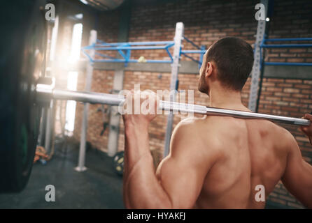 Vue arrière de l'homme avec un barbell Banque D'Images