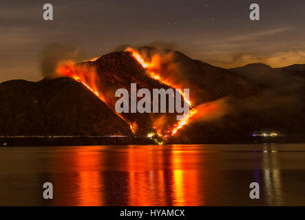 Images spectaculaires montrent une montagne engloutie par incendie, ainsi que les efforts d'air d'urgence de l'éteindre. La protection civile italienne fire fighter aircraft appelé Canadair ont consacré 30 heures luttent pour éteindre un incendie qui a couvert 2 000 hectares de terres, la destruction de chêne, charme et de hêtres. Conservateur de jardin (49) Alfredo Costanzo a pris le coups spectaculaires à Tremezzo, dans la province de Côme, où l'incendie qui, selon les experts, a été délibérément lancée, est l'une des pires de 20-ans. Banque D'Images