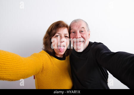 Senior couple coller langues, tenant. selfies Studio shot. Banque D'Images