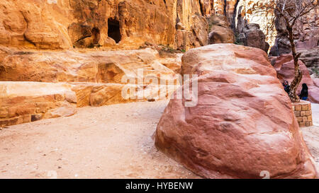 PETRA, JORDANIE - février 21, 2012 : les touristes près de grottes dans Al Siq gorge à l'ancienne ville de Petra en hiver. Rock-cut Petra ville a été établie sur 312 Banque D'Images