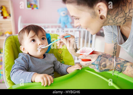 Alimentation maman garçon avec du yaourt Banque D'Images