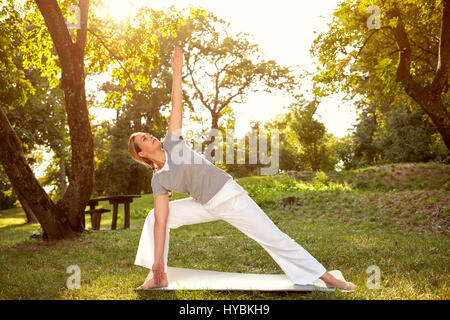 Femme se détend avec body balance exercises in park Banque D'Images