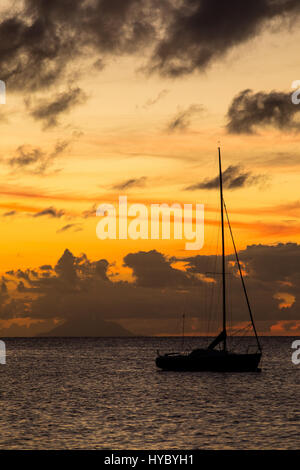 Voilier silhouette sur le coucher du soleil à Dickenson Bay, Antigua. Banque D'Images