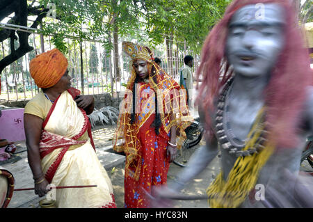 Inde : Bédeille Festival - 21/03/2014 - Inde / / Agartala Tripura - gens habillés comme Dieu Shiva et la Déesse Gouri, danse après la prise d'canabbies à Agartala, capitale de la nord-est de l'Etat de Tripura. C'est une partie de Bédeille Festival, un festival folklorique de l'Inde. Bédeille est une fête hindoue célébrée principalement dans l'état indien du Bengale-Occidental. Il est associé à de telles divinités comme Shiva, Neel et Dharmathakur. Bédeille s'étend sur environ d'une semaine, s Banque D'Images