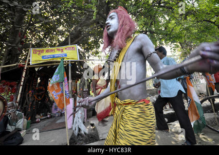 Inde : Bédeille Festival - 21/03/2014 - Inde / / Agartala Tripura - gens habillés comme Dieu Shiva et la Déesse Gouri, danse après la prise d'canabbies à Agartala, capitale de la nord-est de l'Etat de Tripura. C'est une partie de Bédeille Festival, un festival folklorique de l'Inde. Bédeille est une fête hindoue célébrée principalement dans l'état indien du Bengale-Occidental. Il est associé à de telles divinités comme Shiva, Neel et Dharmathakur. Bédeille s'étend sur environ d'une semaine, s Banque D'Images