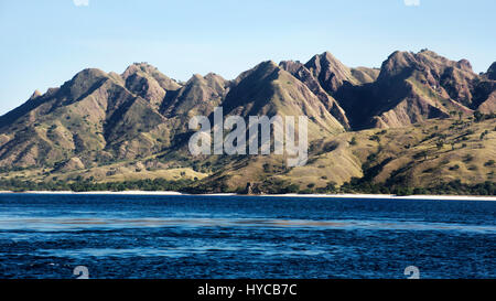 La végétation verte paysage de montagne avec plage de sable blanc et bleu de la mer littoral a son pied à Bajawa Labuanbajo, Indonésie. Banque D'Images