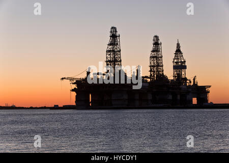 Les appareils de forage en eau profonde temporairement dans l'entreposage, le coucher du soleil, l'Île Harbour, Port Canyon, Arius Port Aransas pétroliers. Banque D'Images