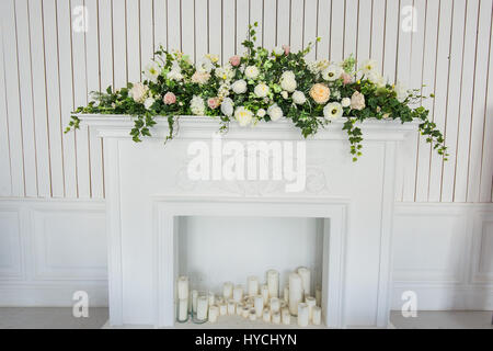 Bouquet de fleurs sur fond blanc cheminée dans un intérieur classique. Banque D'Images