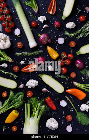 La cuisson des aliments et ingrédients d'assaisonnement sur fond noir. Légumes colorés sur fond de bois. Régime alimentaire sain concept. La nutrition biologique végétarienne. Voir bof Banque D'Images