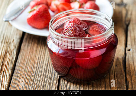 La confiture de fraise dans un bocal en verre sur la table en bois et de baies fraîches. Les conserves maison Banque D'Images