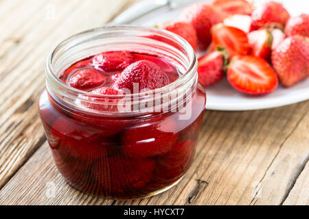 La confiture de fraise dans un bocal en verre sur la table en bois et de baies fraîches. Les conserves maison Banque D'Images