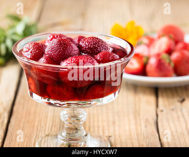 La confiture de fraise dans un bocal en verre sur la table en bois et de baies fraîches. Les conserves maison Banque D'Images