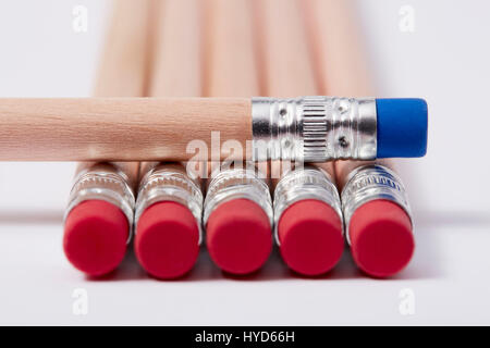 Crayons en bois avec gommes rouges, dont un bleu sur le dessus Banque D'Images