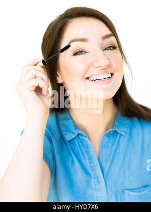 Woman applying mascara Banque D'Images