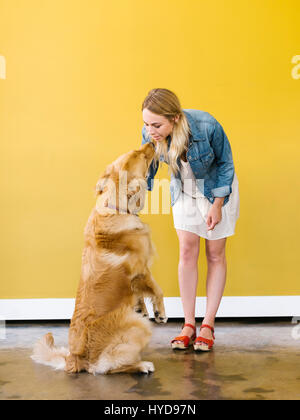 Jeune femme jouant avec Golden Retriever Banque D'Images