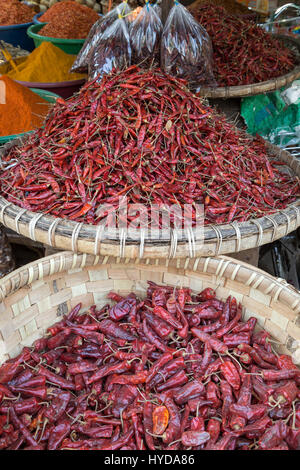 Beaucoup de piments séchés en paniers tissés et des tas d'épices à l'Zegyo (également connu sous le nom de Zay Cho) Marché à Mandalay, Myanmar (Birmanie). Banque D'Images