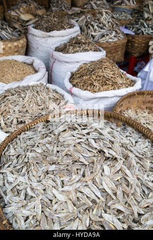 Beaucoup de petits poissons séchés en paniers tissés et sacs au Zegyo (également connu sous le nom de Zay Cho) Marché à Mandalay, Myanmar (Birmanie). Banque D'Images