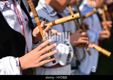 Les gens en costumes traditionnels le chant à flûtes en bois Banque D'Images