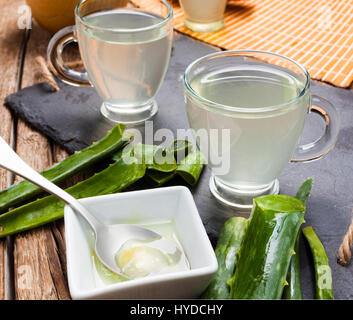 Boire de l'aloe vera et miel. Tasses en verre sur un plateau d'ardoise Banque D'Images