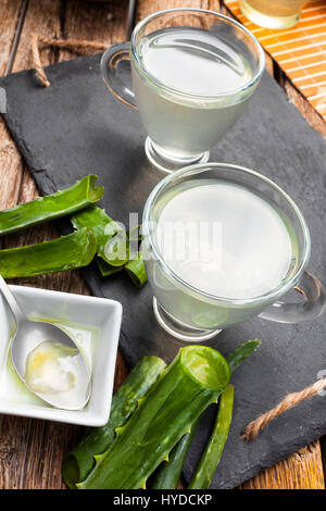 Boire de l'aloe vera et miel. Tasses en verre sur un plateau d'ardoise Banque D'Images