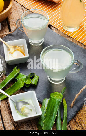 Boire de l'aloe vera et miel. Tasses en verre sur un plateau d'ardoise Banque D'Images