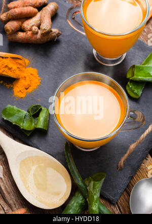 Boisson chaude à l'aloe vera et le curcuma. Tasses en verre sur un plateau d'ardoise Banque D'Images