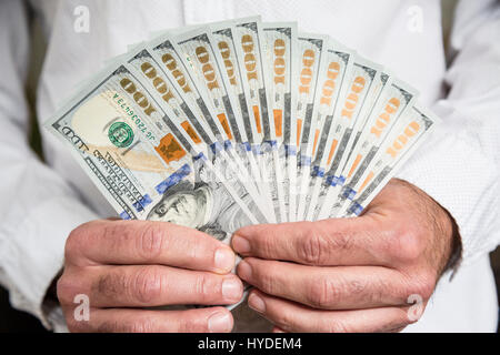 Un homme utilise les deux mains pour une pile de toute nouvelle d'une centaine de dollars en devises américaines Banque D'Images