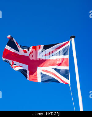 Union Jack flag against blue sky Banque D'Images