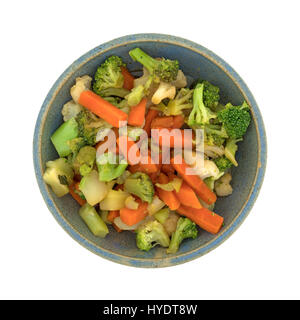 Vue de dessus d'un vieux bol en grès rempli de carottes, brocoli et chou-fleur en sauce isolé sur un fond blanc. Banque D'Images