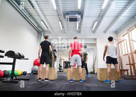 Les hommes en sport avec des formateurs sur l'exercice de mettre en place des boîtes. Banque D'Images
