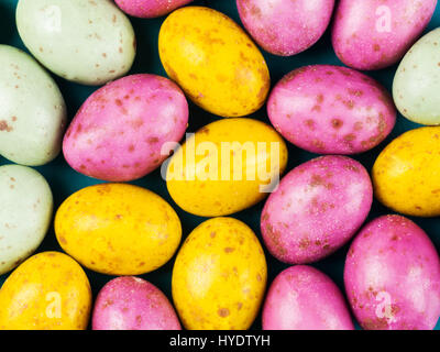 Sélection de mini oeufs en chocolat de Pâques colorés sur fond noir Banque D'Images