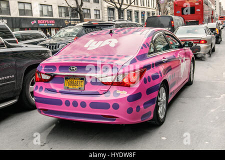 Une voiture rose avec logo Lyft est sur la 14e rue à Manhattan. Banque D'Images