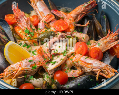 Des fruits de mer colorés avec des légumes et épices sur plaque bleue en restaurant. Close up Banque D'Images