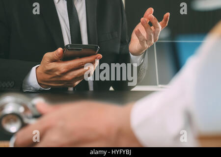 Concept de travail médical,médecin travaillant pour téléphone intelligent et tablette numérique et ordinateur portable à son équipe, en réunion de bureau moderne à l'hôpital Banque D'Images