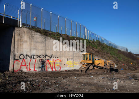 Janvier,2016. des machines nettoyer la zone où les réfugiés avaient construit des abris dans le camp de réfugiés dans les dunes de Calais, France.Le camp de réfugiés de Calais est à l'étape finale d'être effacée par la police française. Les images montrent comment les bulldozers protégés par des agents de sécurité ont à peine laissé une trace de ce qui était autrefois regroupée sur les refuges. Le camp controversé, qui a été la maison pour environ 6 000 migrants principalement de la Syrie et de l'Afrique du Nord, est supprimé de façon constante par les autorités. Banque D'Images