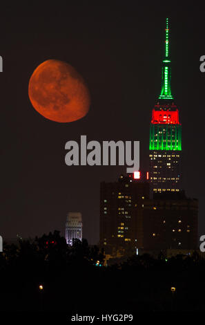 NEW YORK, USA : de superbes photos de l'Empire State Building avec une orange moon passer ont été capturés. Les images montrent comment l'un des bâtiments les plus emblématiques de l'air encore plus impressionnante avec notre lune orange éclatant d'overhead. D'autres photos montrent le soleil se lever et le Manhattan Pont de Brooklyn. Rédacteur technique américaine Jennifer Khordi (46) a été en mesure de saisir ces photos à couper le souffle de l'horizon de Jersey City et Kearny ville dans le New Jersey. Banque D'Images