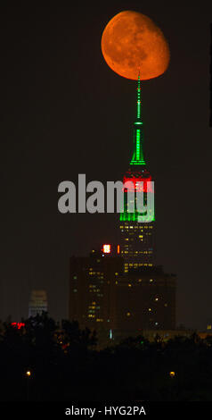 NEW YORK, USA : de superbes photos de l'Empire State Building avec une orange moon passer ont été capturés. Les images montrent comment l'un des bâtiments les plus emblématiques de l'air encore plus impressionnante avec notre lune orange éclatant d'overhead. D'autres photos montrent le soleil se lever et le Manhattan Pont de Brooklyn. Rédacteur technique américaine Jennifer Khordi (46) a été en mesure de saisir ces photos à couper le souffle de l'horizon de Jersey City et Kearny ville dans le New Jersey. Banque D'Images