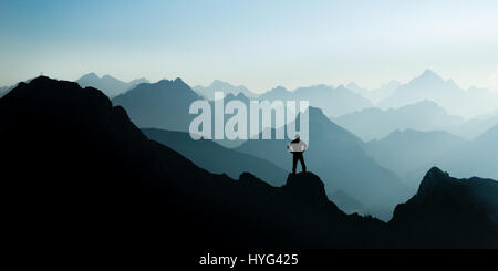 Les chaînes de montagnes spectaculaires silhouettes. homme atteindre sommet mondial jouissant de la liberté. Banque D'Images