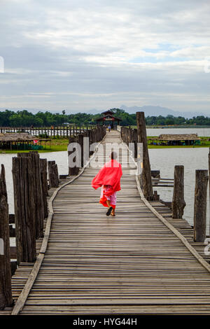 Amarapura, Myanmar - 28 juin, 2015 : Jeune moine marche sur un pont U Bein dans Amarapura, Myanmar Banque D'Images