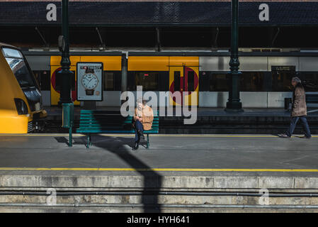 Femme o un banc de la gare de São Bento dans la ville de Porto sur la péninsule ibérique, deuxième plus grande ville du Portugal Banque D'Images