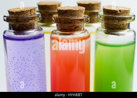 Trois flacons de laboratoire de mesure de liquides sur un fond blanc. Banque D'Images